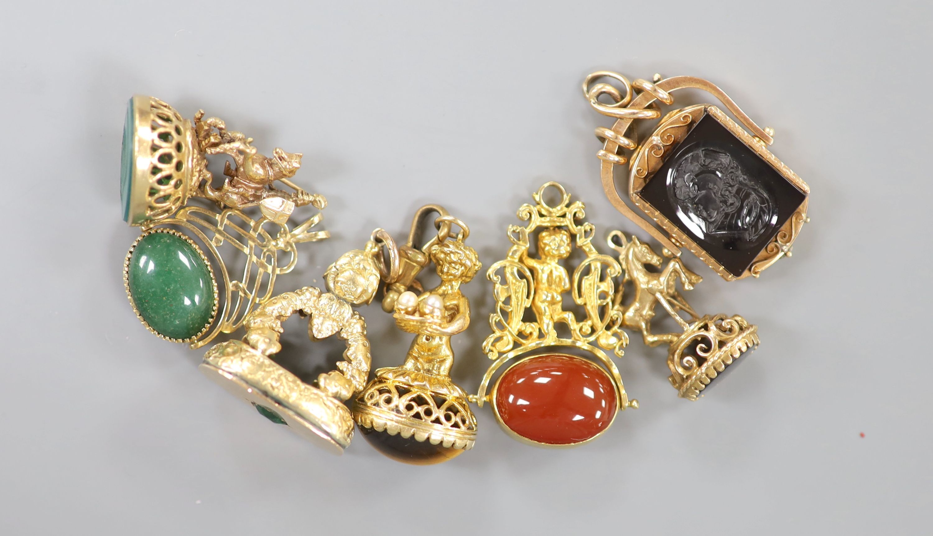 Seven assorted modern yellow metal overlaid and gem set fob seals including two 'spinning' (one with locket), largest 43mm, five stamped 9ct gold.